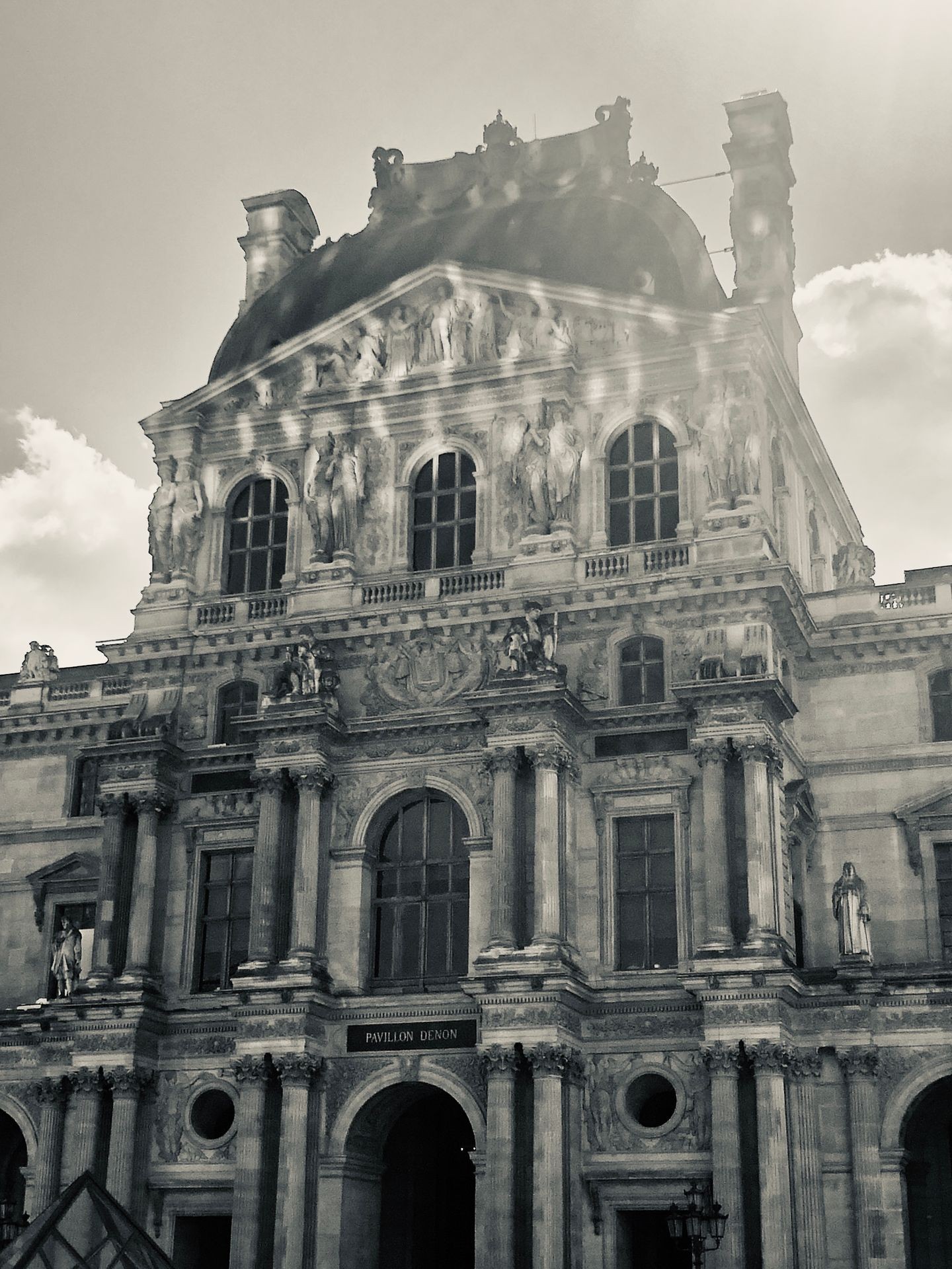 Black and white photo of a grand historic building with ornate sculptures and architectural details on its facade.